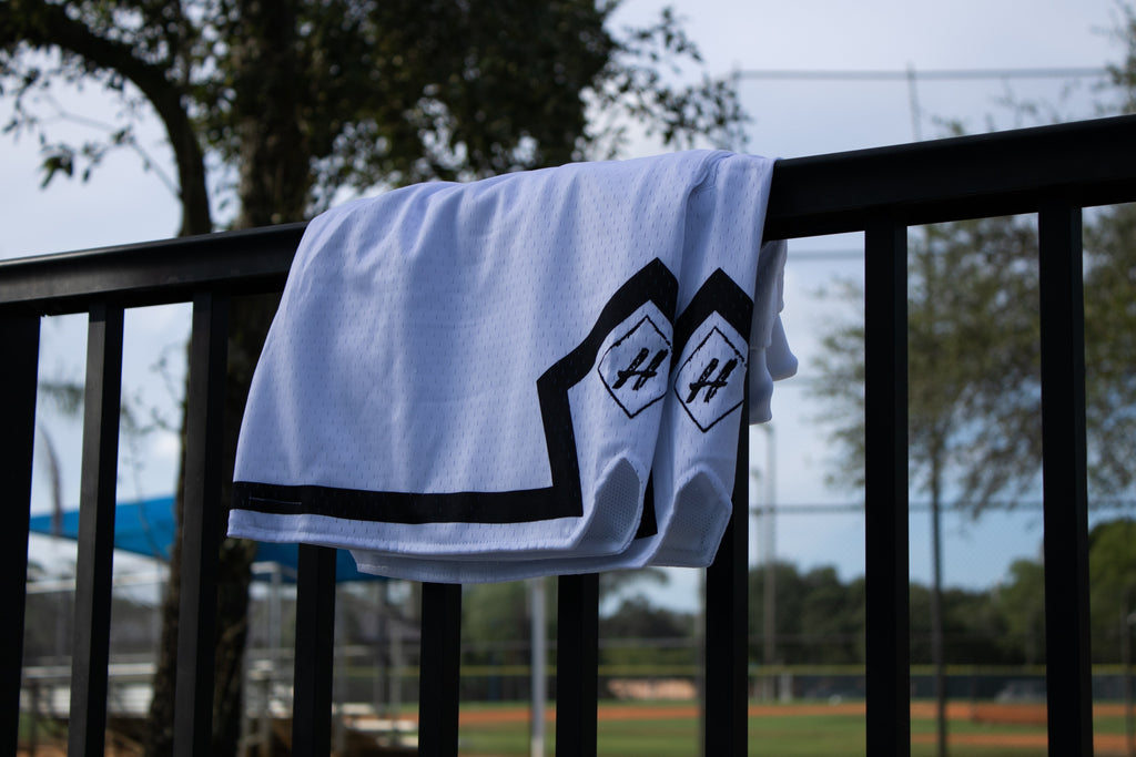 Pure White Board Member Shorts is now available at our store with an inside draw string and light mesh. It features a pitch black line surrounding the bottom of the shorts with our signature H logo stitched on encapsulated by a neat sable diamond. 